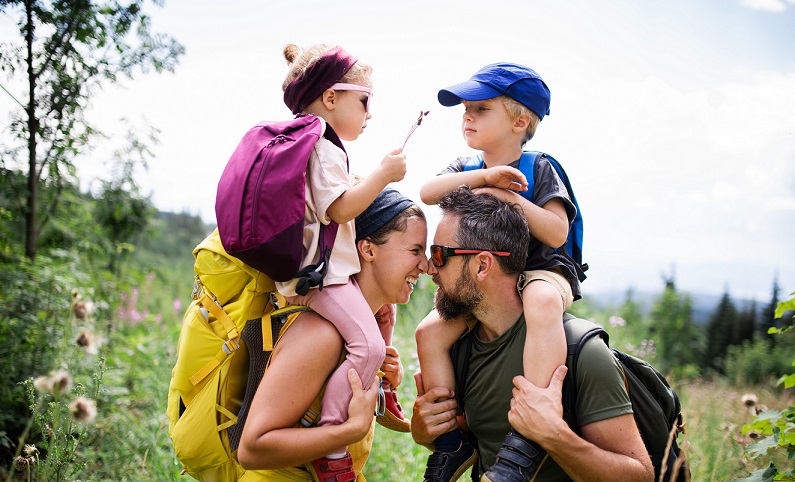 A family of four enjoys a hike in a scenic outdoor setting.