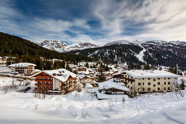 Snow-covered village nestled in a mountainous winter landscape.