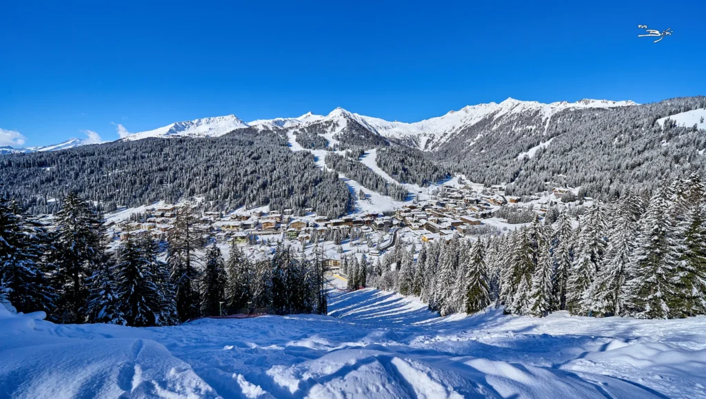 Madonna di Campiglio innevata tra i boschi, con le piste da sci sui pendii
