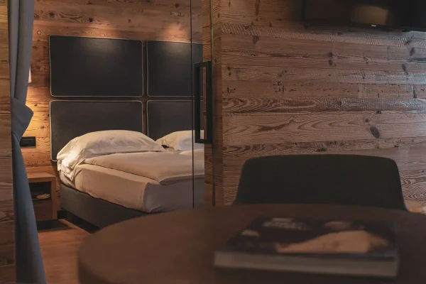 Camera da letto accogliente con pareti in legno e un letto matrimoniale.