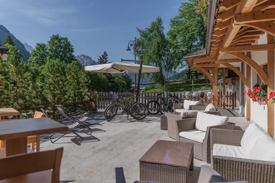 Outdoor patio with wicker furniture, bicycles, and mountain view.
