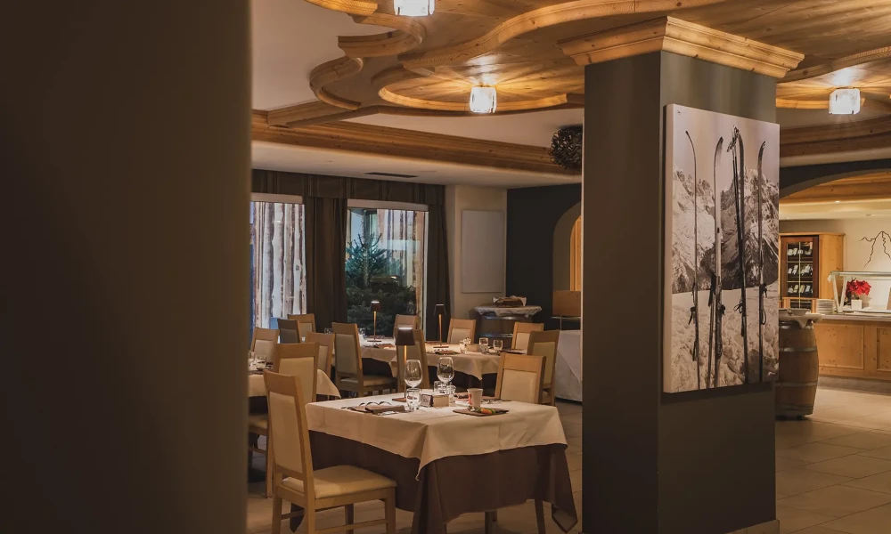 Interno elegante di un ristorante con tavoli apparecchiati e decorazioni in legno.