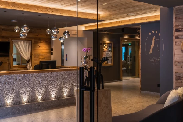 Reception di un hotel elegante con arredi moderni e caldi dettagli in legno.